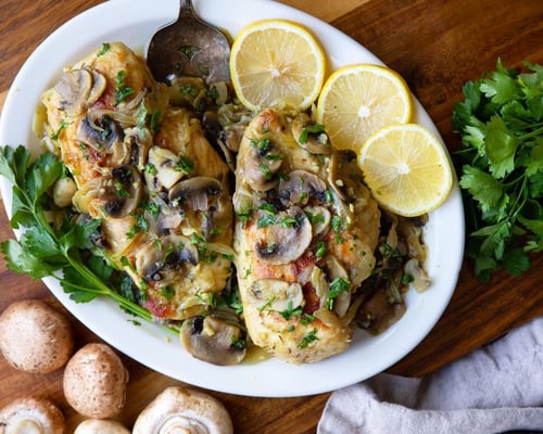 Chicken and mushrooms served with parsley and lemon wedges