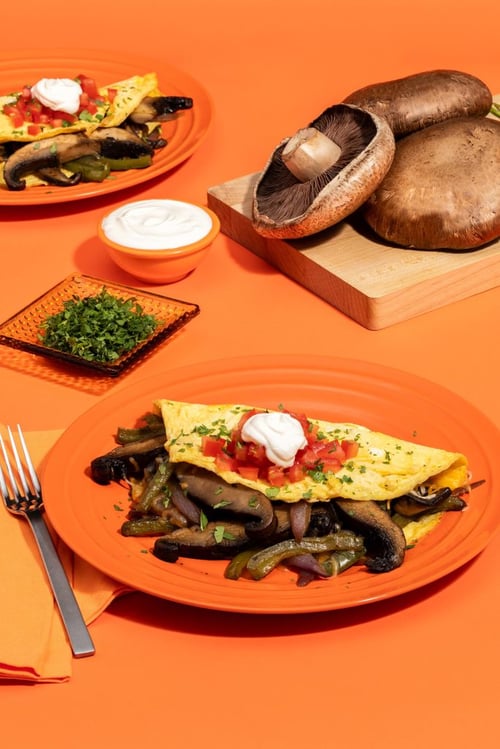 Mushroom omelete with fork and cilantro and sour cream 